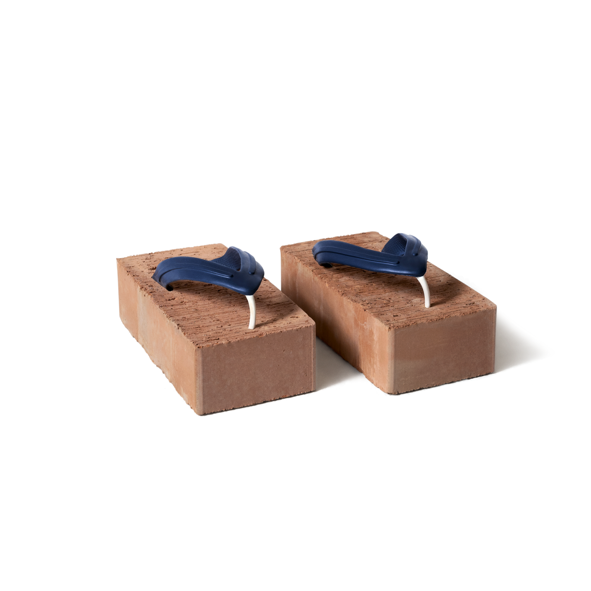 Flip Flops aus Ziegelsteinen, symbolisiert extra Service & Beratung bei Bank99-Produkten