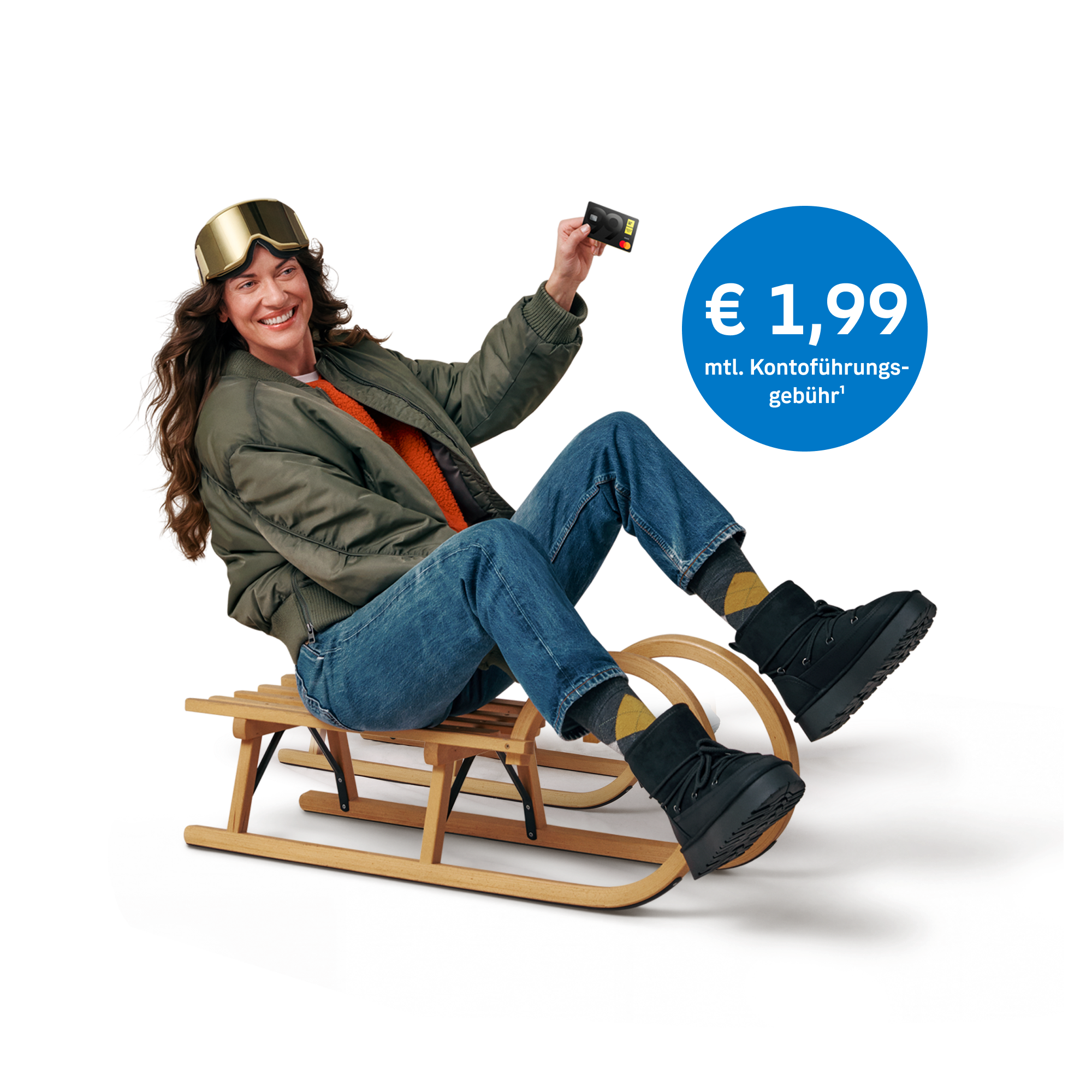 Person mit Skibrille sitzt auf einem Holzschlitten und hält eine bank99 Karte in die Höhe. Blauer Kreis mit "€ 1,99 monatlicher Kontoführungsgebühr"