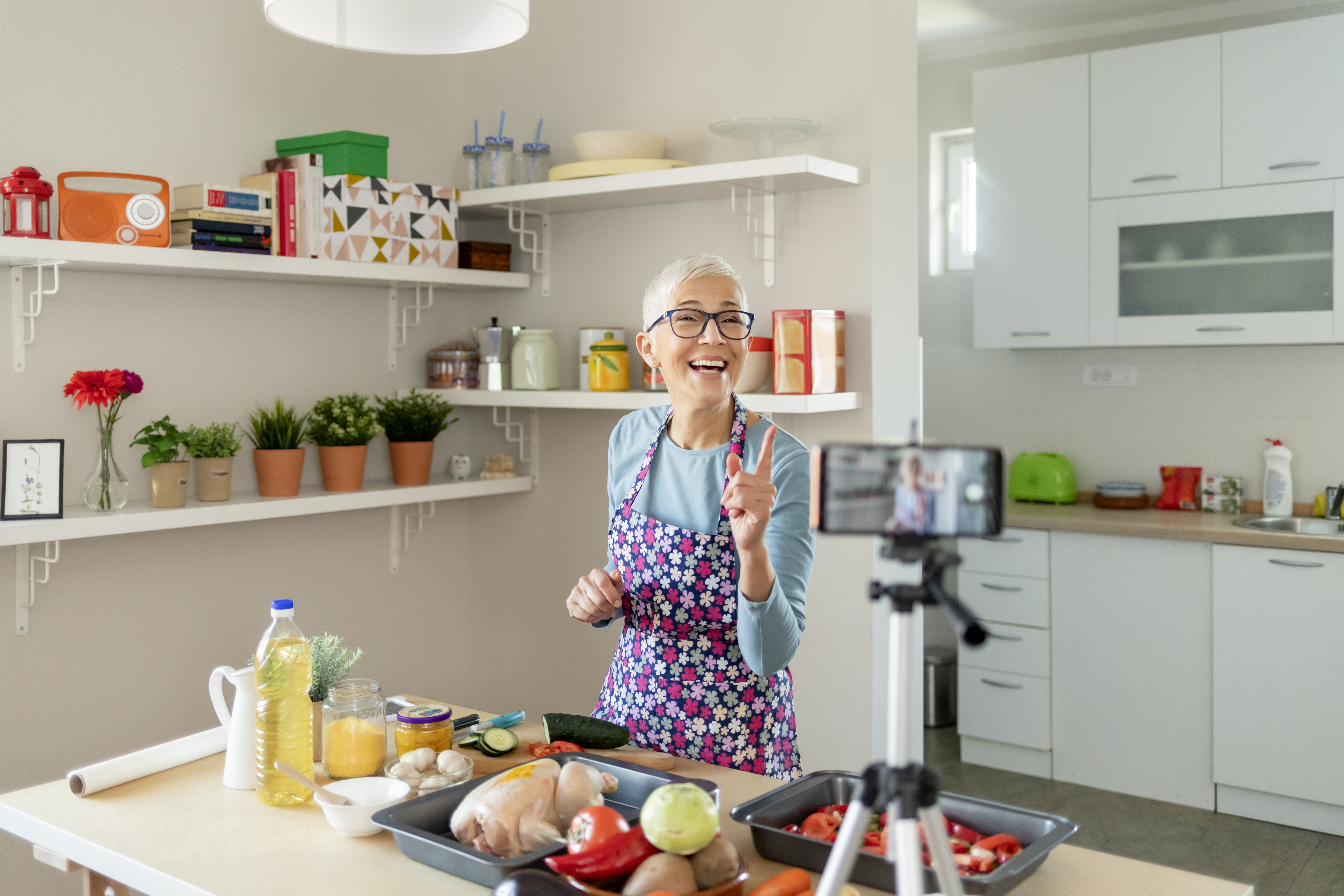 Ältere Influencerin nimmt in Küche Video mit Rezeptanleitung auf