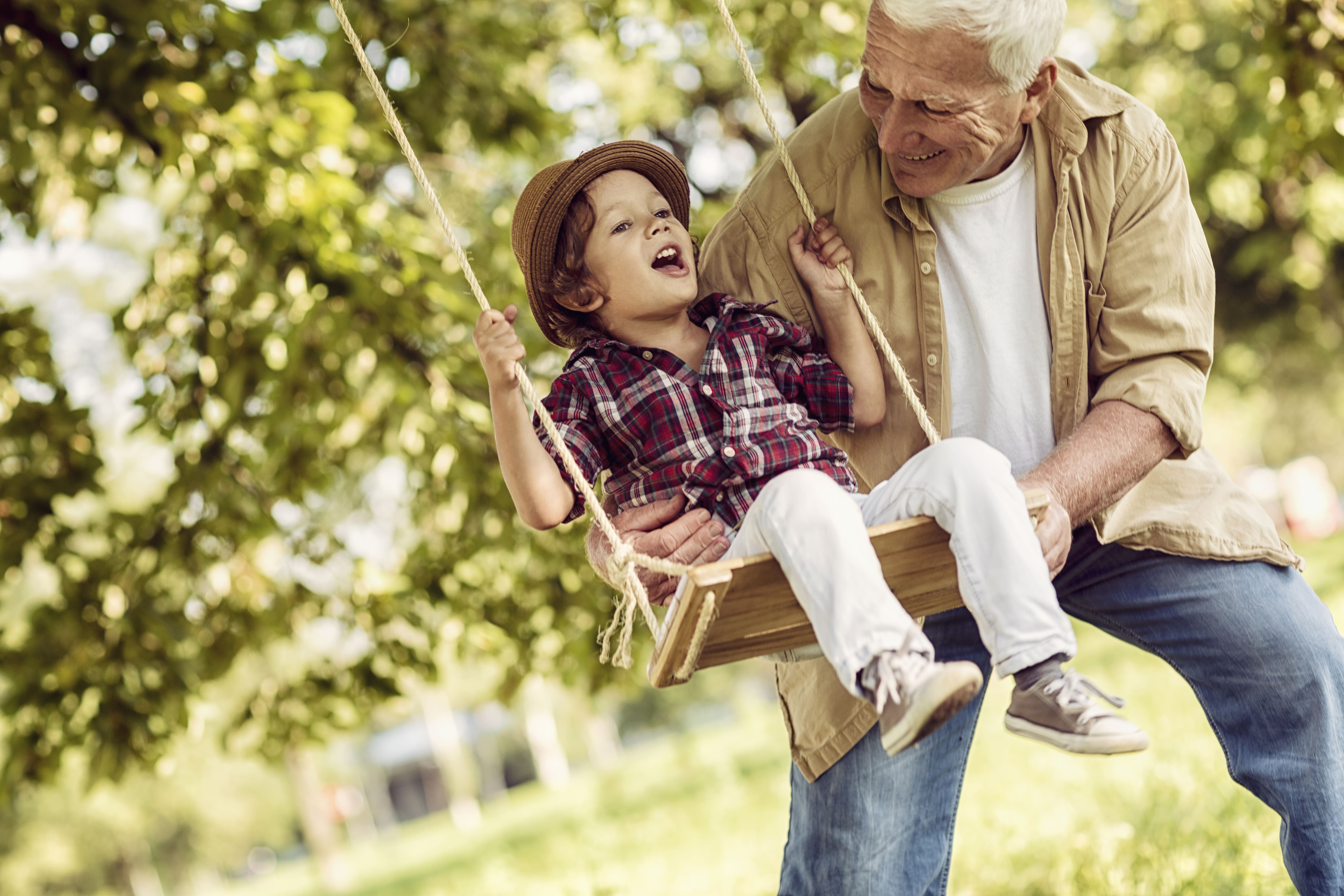 Ein Großvater spielt mit seinem Enkel – eine Anspielung auf langfristiges Sparen.