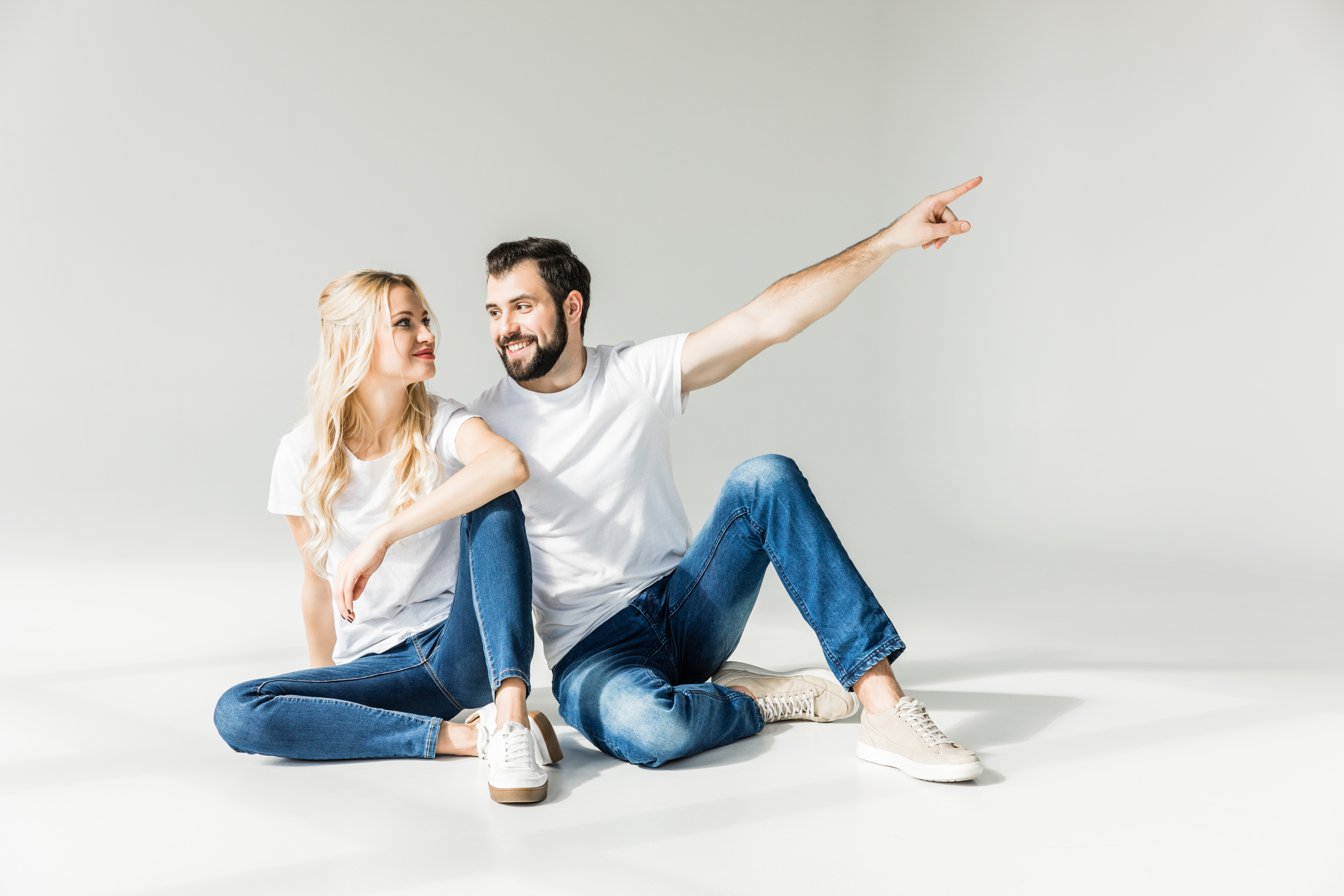 Ein Pärchen sitzt am Boden, der Mann zeigt nach oben – symbolisch für den Rückblick auf 2024.